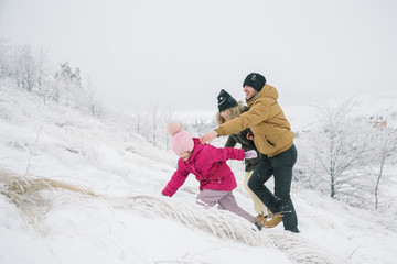 family climbs the hill and having fun