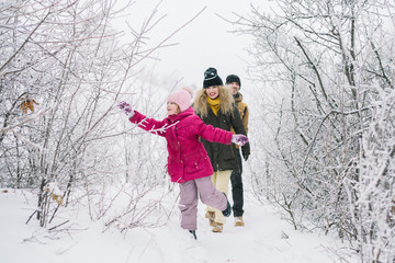 Fototapeta na wymiar happy family walking on the snowy woods