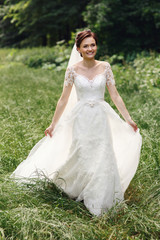 Obraz na płótnie Canvas Gorgeous princess bride in white dress posing in sunny park