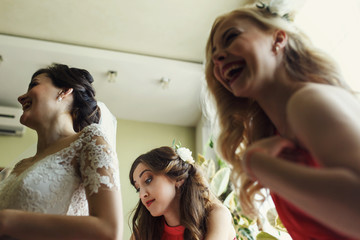 Beautiful bride getting prepared for wedding with bridesmaids