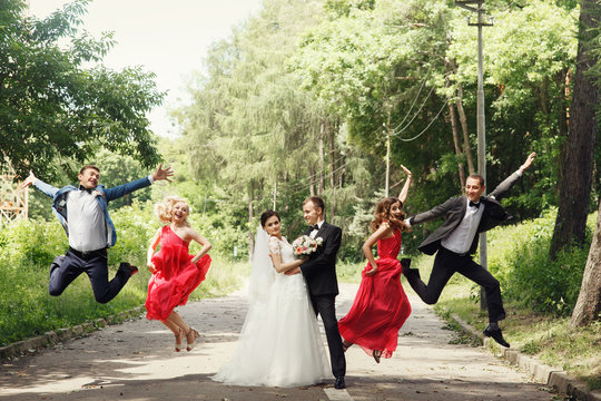 Groomsmen & bridesmaid fun jumping with groom & bride outdoor