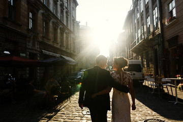 Sun illuminates old city where wedding couple walks