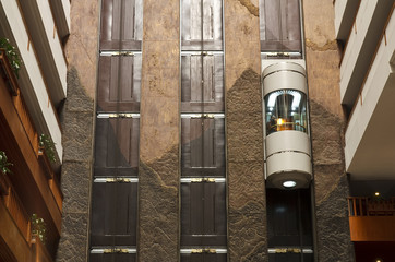 glass capsule elevator with people or tourist in the lift on vin