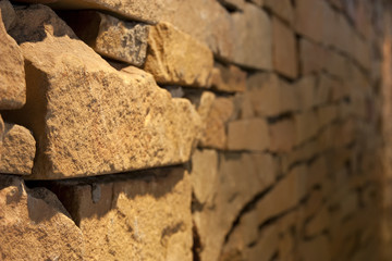 old yellow granite or stone wall side focus at archaeological or