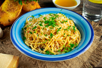Vegetarian Italian Pasta Spaghetti Aglio E Olio with garlic bread, red chili flake, parsley, parmesan cheese and glas of water