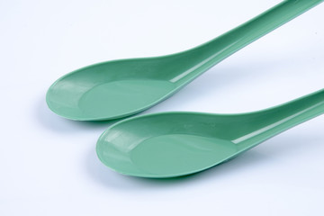 Green plastic sppon over white background.