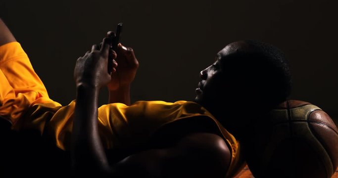 Sportsman using mobile phone while resting in basketball court 4k