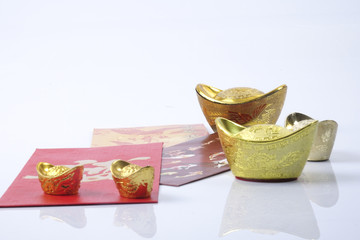 Chinese new year festival decorations, ang pow or red packet and gold ingots. Chinese characters...
