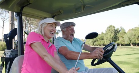 Two golfers driving in their golf buggy at golf course