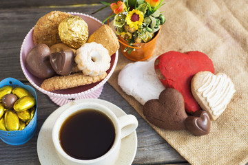 Obraz na płótnie Canvas Heart shaped cookies (big and small as couple), cup of coffee, bouquet of flowers decoration. sunny morning. Romantic breakfast or Valentine's Day Breakfast. Toned image 