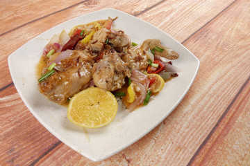 Lemon chicken on wooden background.