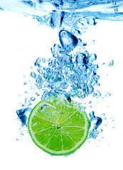 Lime dropped in a water on white background