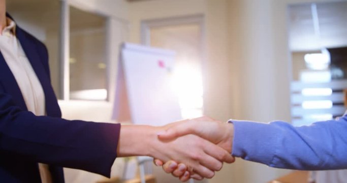 Close-up of female business executives shaking hands in office 4k