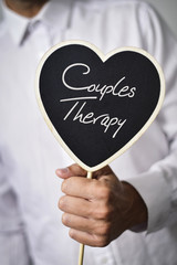 man with signboard with text couples therapy