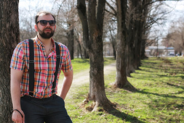 Naklejka na ściany i meble man beard suspender tree park sunglasses