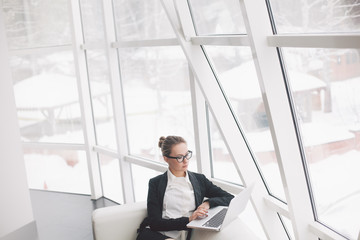 Young business woman using laptop in office.