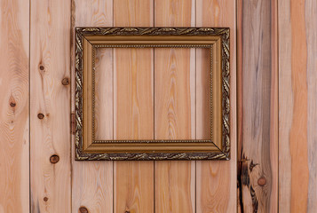 blank vintage gold frame on the old wooden background