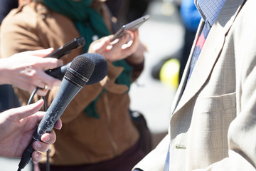 Journalist holding a microphone conducting an TV or radio interview