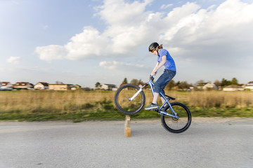 Fototapeta na wymiar Jugendlicher übt Tricks, Sprünge mit dem Bike auf der Strasse