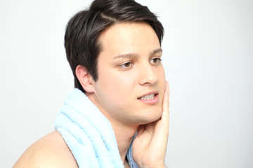 young man toweling his face, men's skin care concept