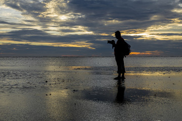 Silhouette of photographer at the beach during sunset.