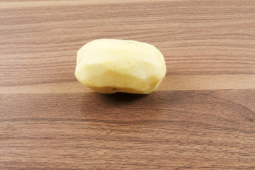 Fresh raw potato on wood table.