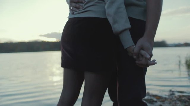 Close up view of stylish couple holding their hands and hugging each other passionately by the riverside. Forever together. Love story. Happy moments. Outside shooting.