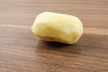 Fresh raw potato on wood table.