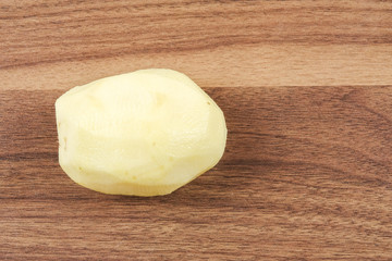 Fresh raw potato on wood table.