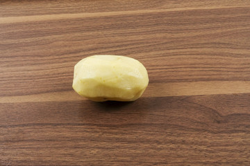 Fresh raw potato on wood table.