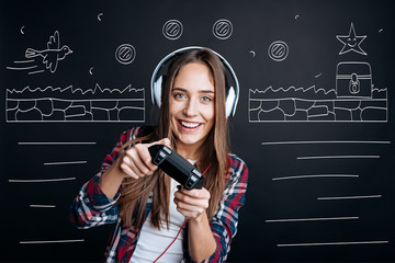 Cheerful delighted young woman playing video games