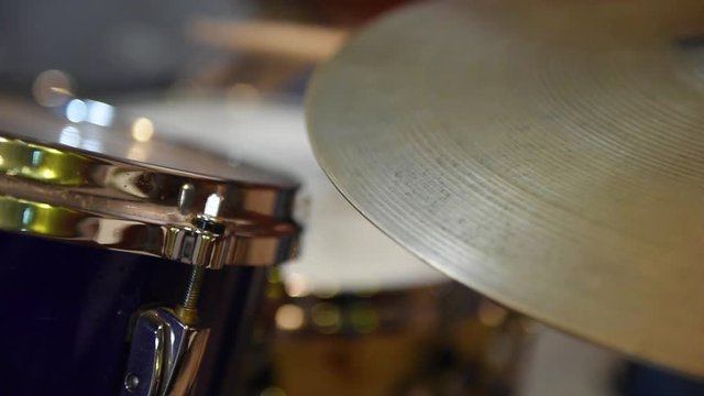 Drummer playing instrument. Closeup on hi hat cymbal movement with musician in background