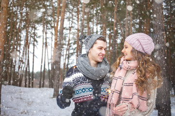 Beautiful girl with long hair man in love walking in the winter forest, obnimayutsya, love, sparklers festive lights on Valentine's Day