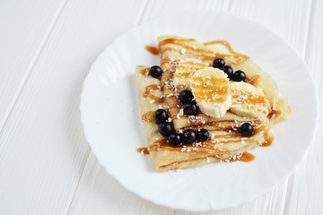 Pancakes with berries and banana on a white background