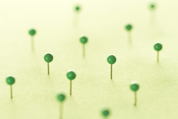 Green pins on green background