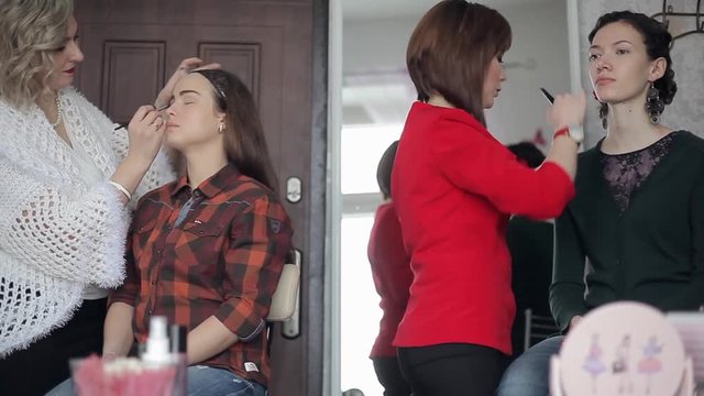 Make-up artists make makeup model