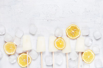 White background with lemon lollies, lemons and ice cubes