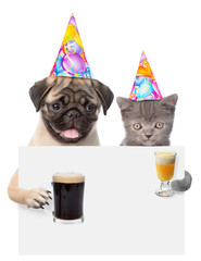 Cat and dog in birthday hats holding beer and cocktail peeking above white banner. isolated on white 