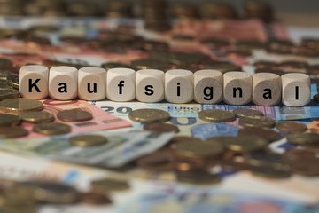 kaufsignal - Holzwürfel mit Buchstaben im Hintergrund mit Geld, Geldscheine