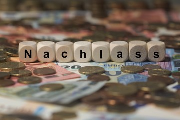 nachlass - Holzwürfel mit Buchstaben im Hintergrund mit Geld, Geldscheine