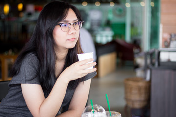 woman drinking water from white paper cup