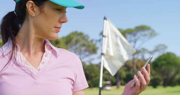 Female golf player using mobile phone at golf course