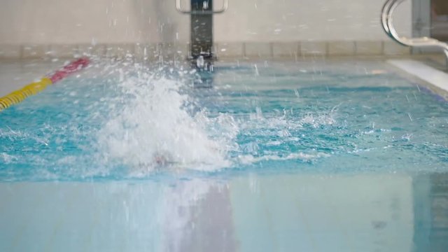 Slowmotion - the woman swimming butterfly in the swimming pool