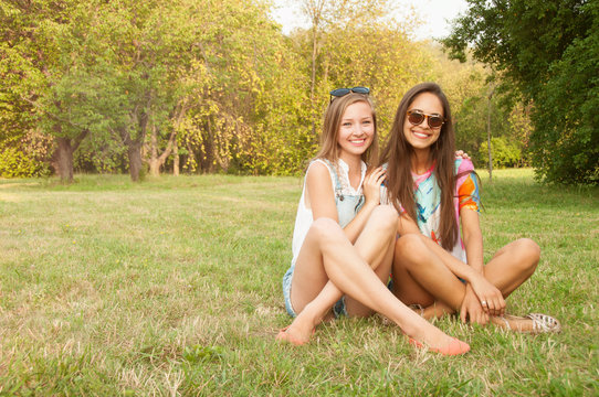 Outdoor lifestyle portrait of two best friends hipster girls wearing stylish bright outfits, t-shirts, denim shorts and glasses, going crazy and having great time together