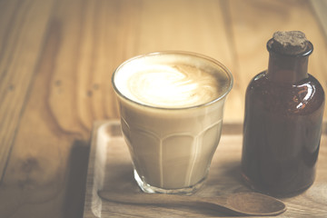 vintage art filter image of coffee latte art in cafe
