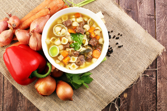 Clear soup with beef and noodles. Broth with carrots, onions var