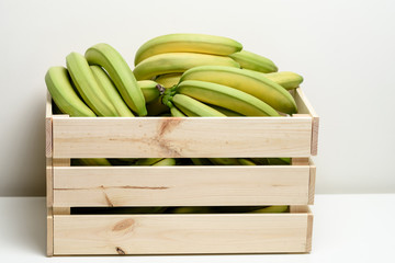Bananas in wooden box, isolated on white background