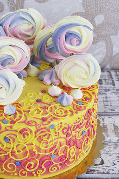 Children's cake rainbow color on a white background with meringue