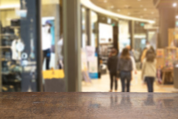 Selective foucus on Empty wooden table with the shopping mall have laday shopping background. For display or montage your products.