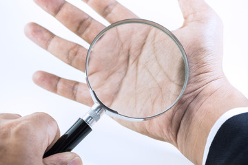 businessman hand holding magnifying glass on palm.